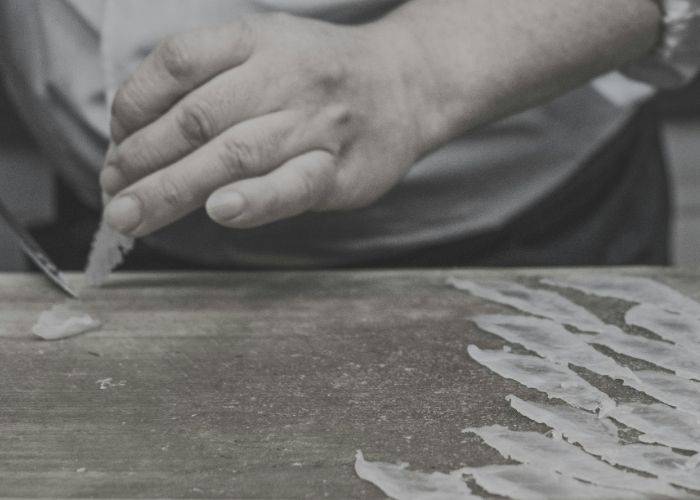 An expert slicing poisonous puffer fish in a black-and-white picture.